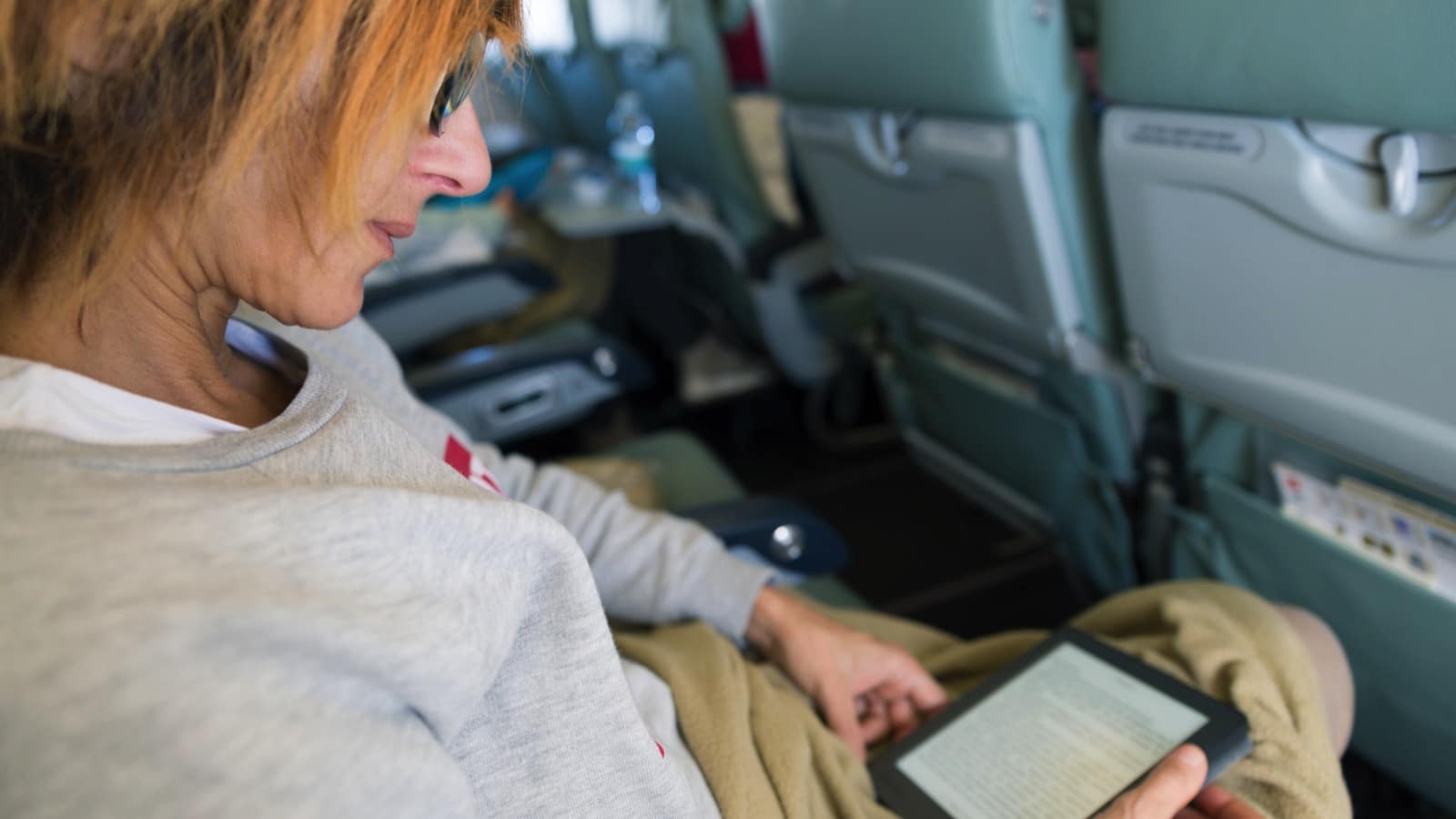 Woman-reading-kindle-in-flight