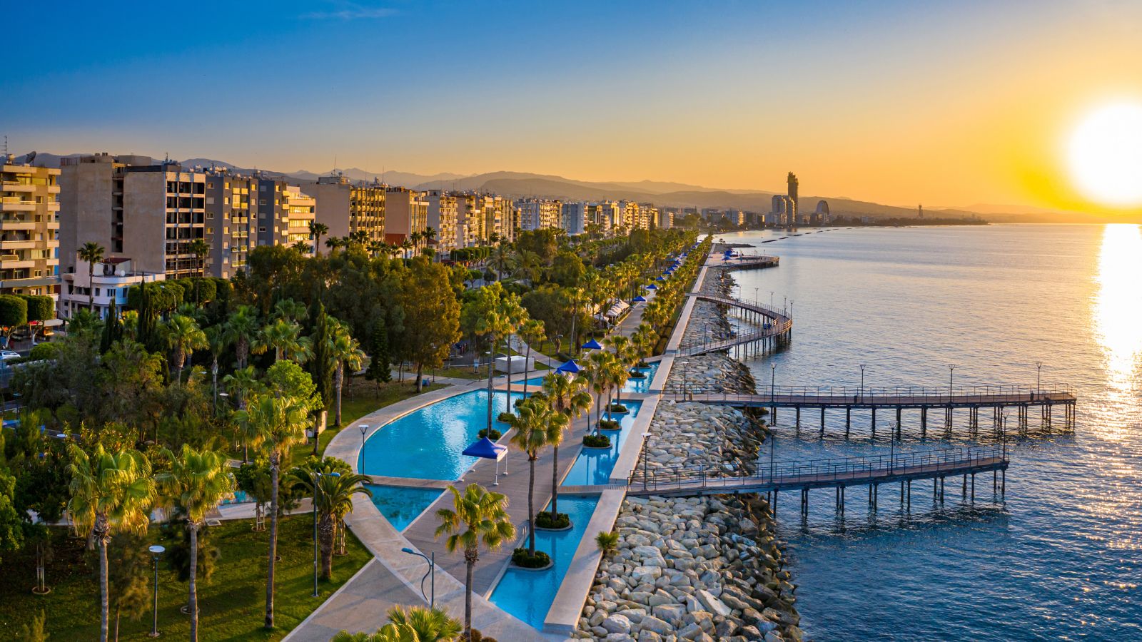 Sunset in Cyprus. The sun sets in the Mediterranean. Limassol at sunset. Evening panorama of Limassol with height. Mediterranean evening landscape. Holidays in Cyprus.