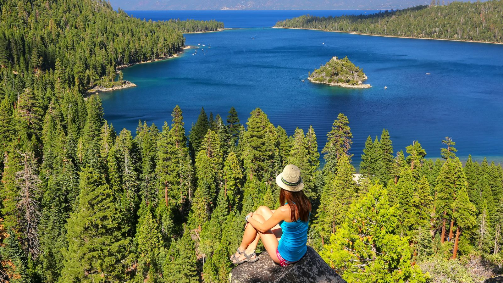 Young woman enjoying the view of Emerald Bay at Lake Tahoe, California, USA. Lake Tahoe is the largest alpine lake in North America