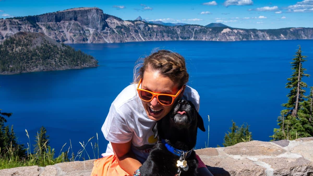 Happy woman tourist enjoys Crater Lake National Park -on the list of the deepest lake in the world