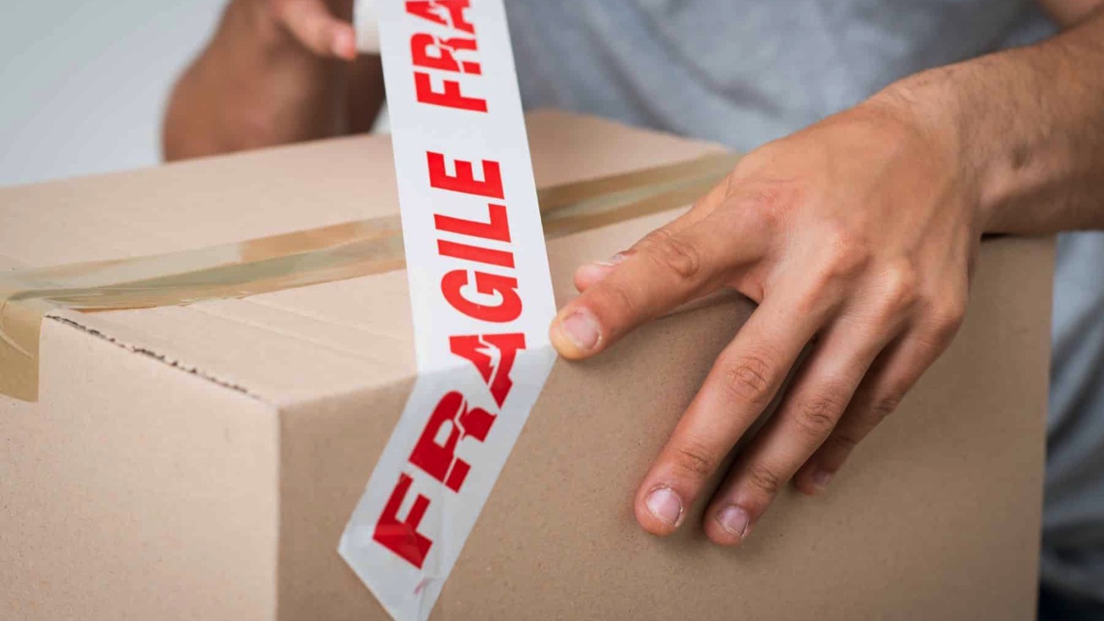 Close-up-Of-A-Man-Packing-Cardboard-Box-With-Sellotape