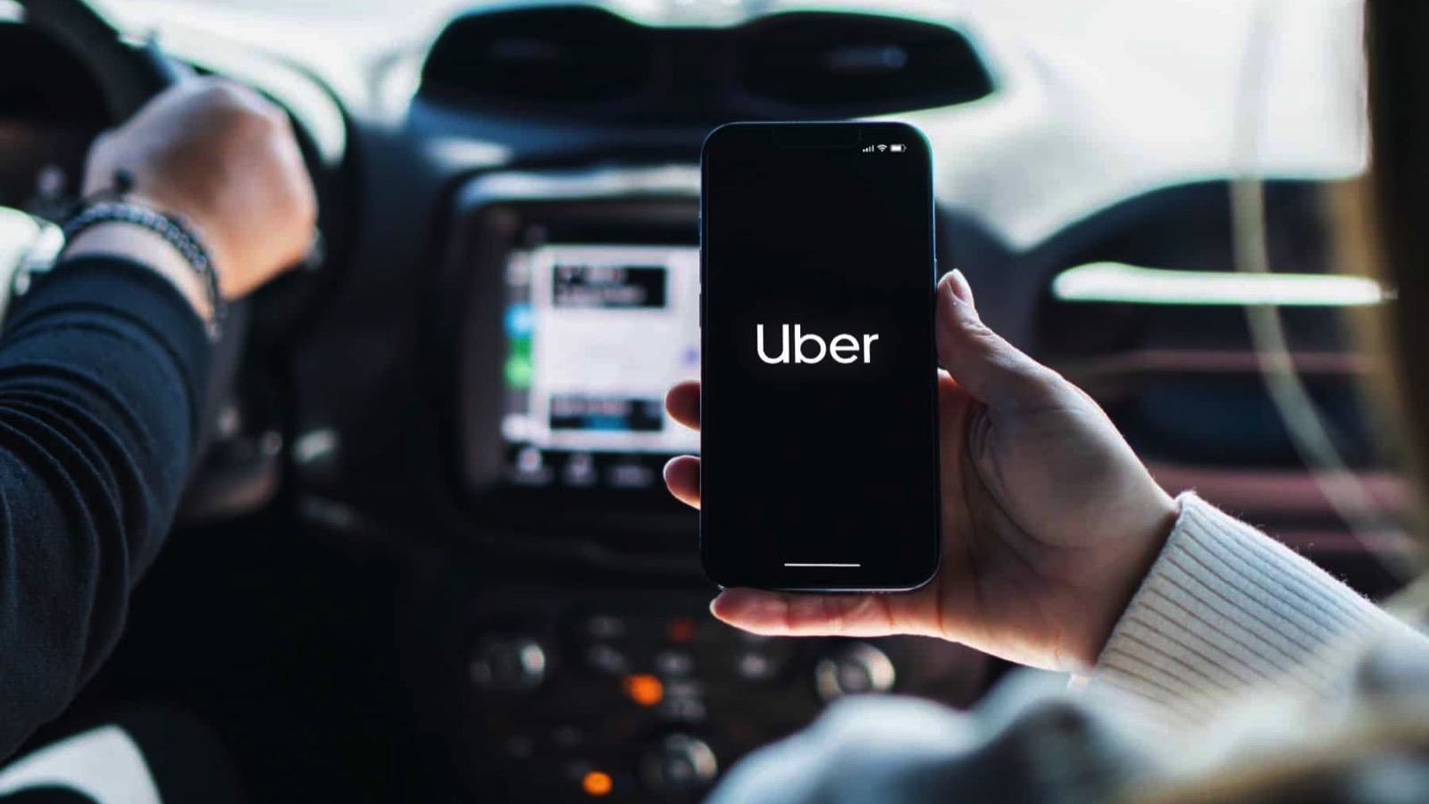 Girl-inside-car-holding-smartphone-with-Uber-app-on-screen