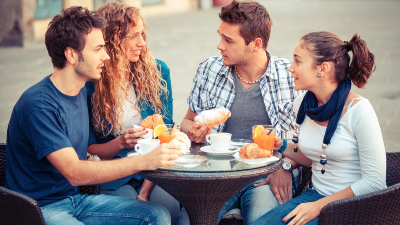 Group of friends having italian breakfast in streets of Italy