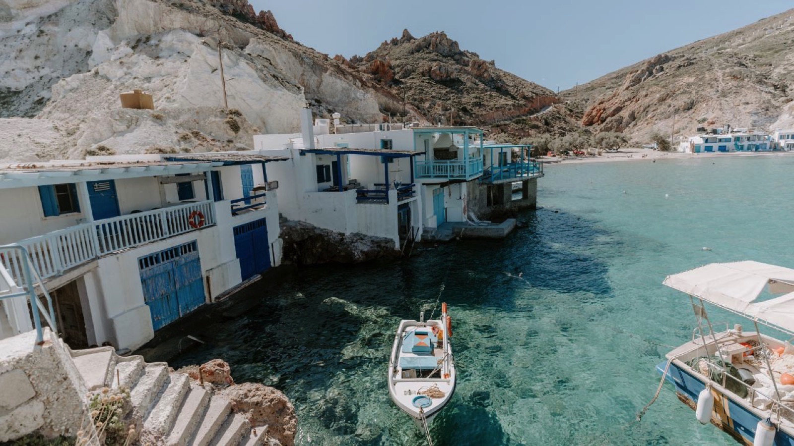 Traditional fisherman houses by the seaside in Milos Island, Greece surrounded by crystal turquoise sea lagoons on a summer day