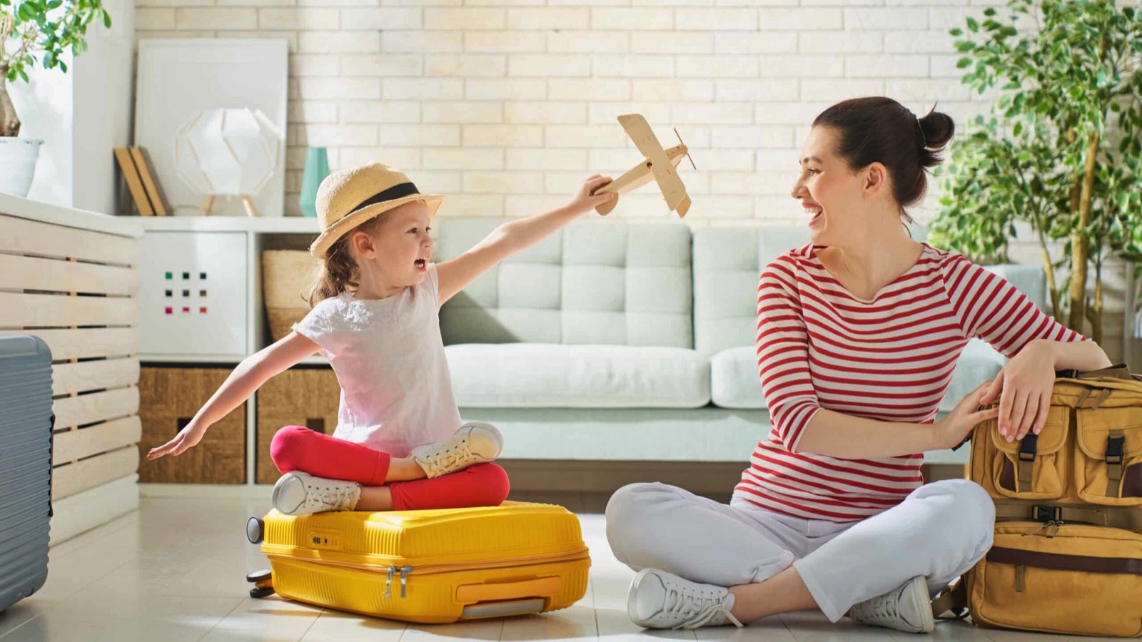 Happy family preparing for the journey. Mom and daughter are packing suitcases for the trip.