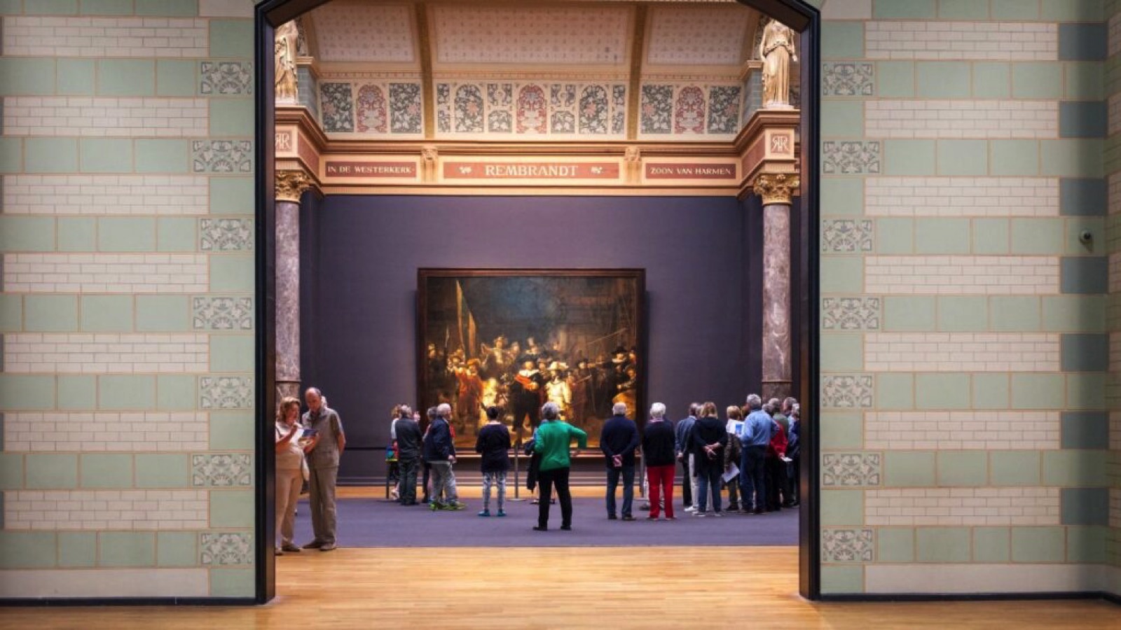 Amsterdam, Netherlands - May 2018: A crowd of people gather around a painting by Rembrandt displayed inside the Rijksmuseum.