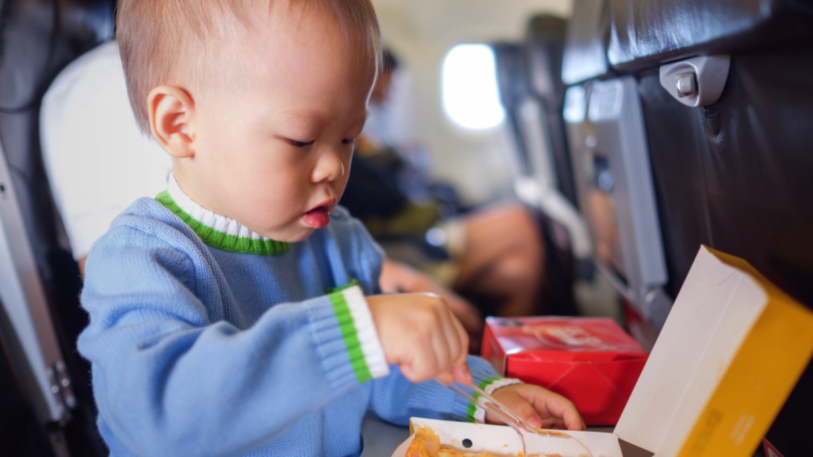 Toddler eating snacks in flight