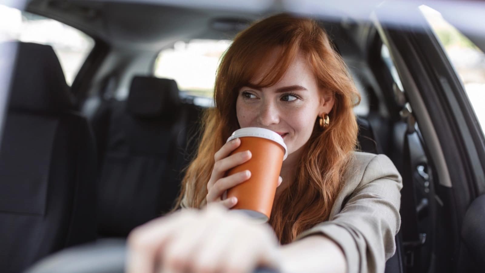 Woman-driving-car-drinking-coffee