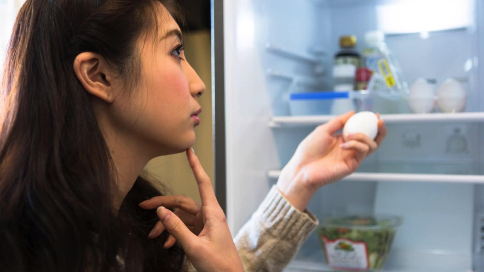 Woman-taking-eggs-out-of-refrigerator