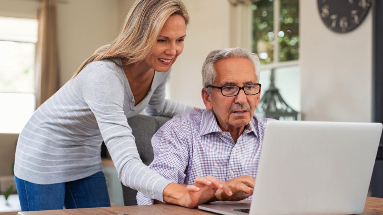 Woman teaching her father about laptop