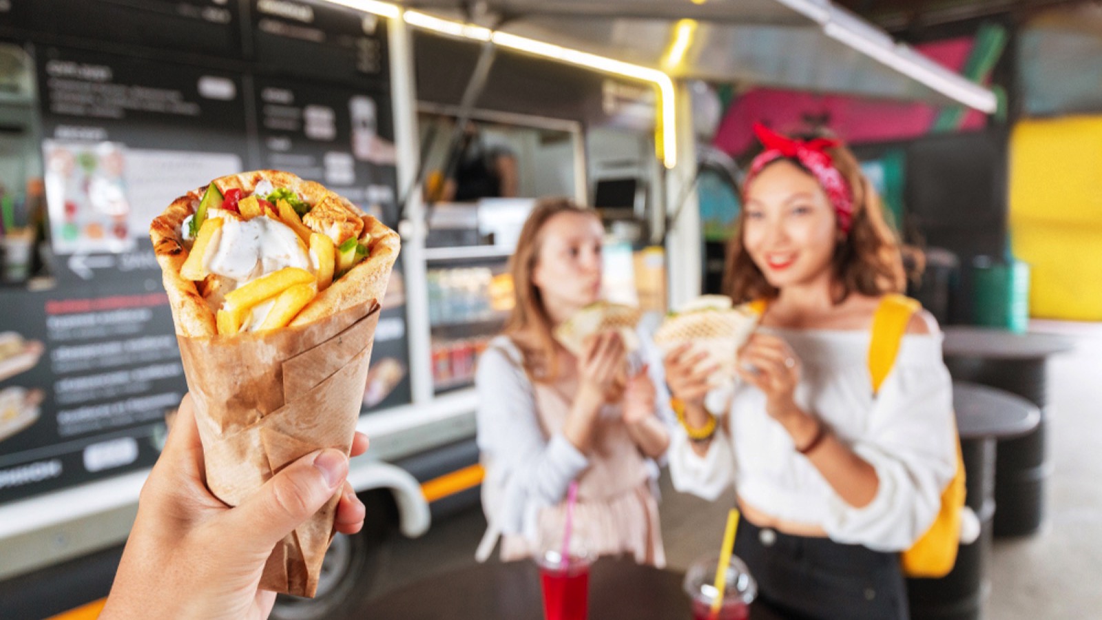 Asian girl tasting traditional greek fastfood gyros kebab