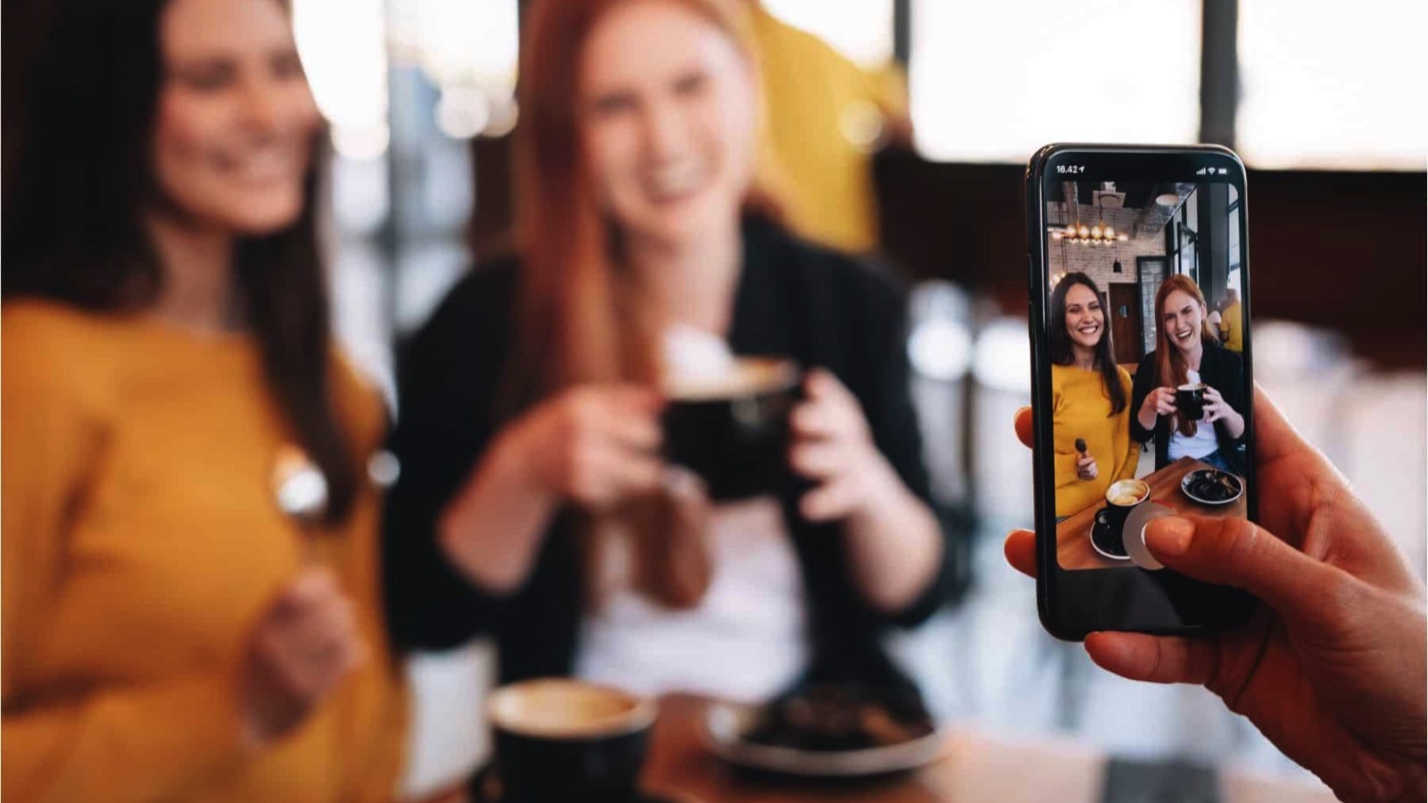 Friends-having-coffee-being-photographed