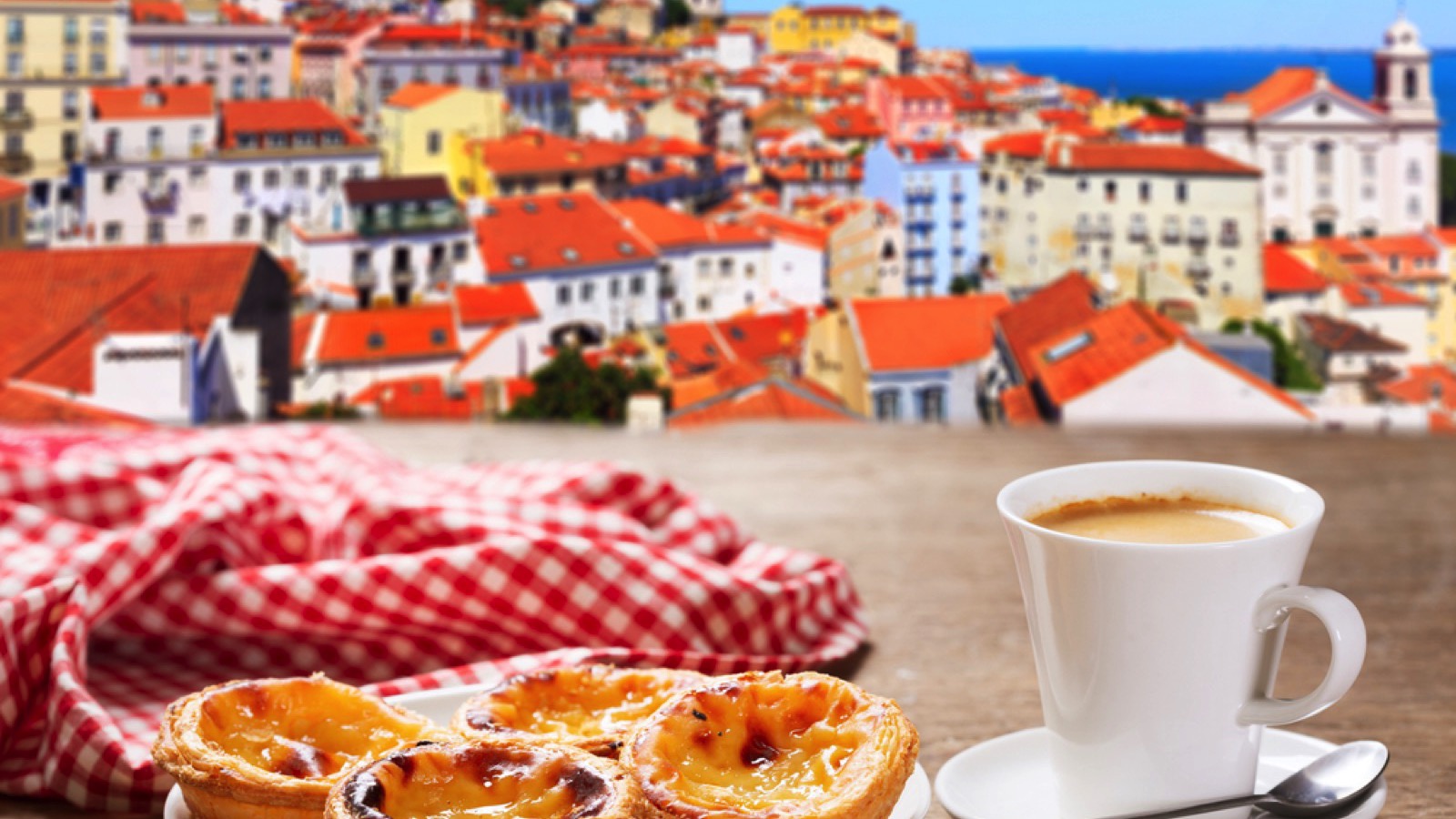 cup of coffee and plate of traditional portuguese pastries - Pastel de nata, over Alfama district, lisbon, Portugal