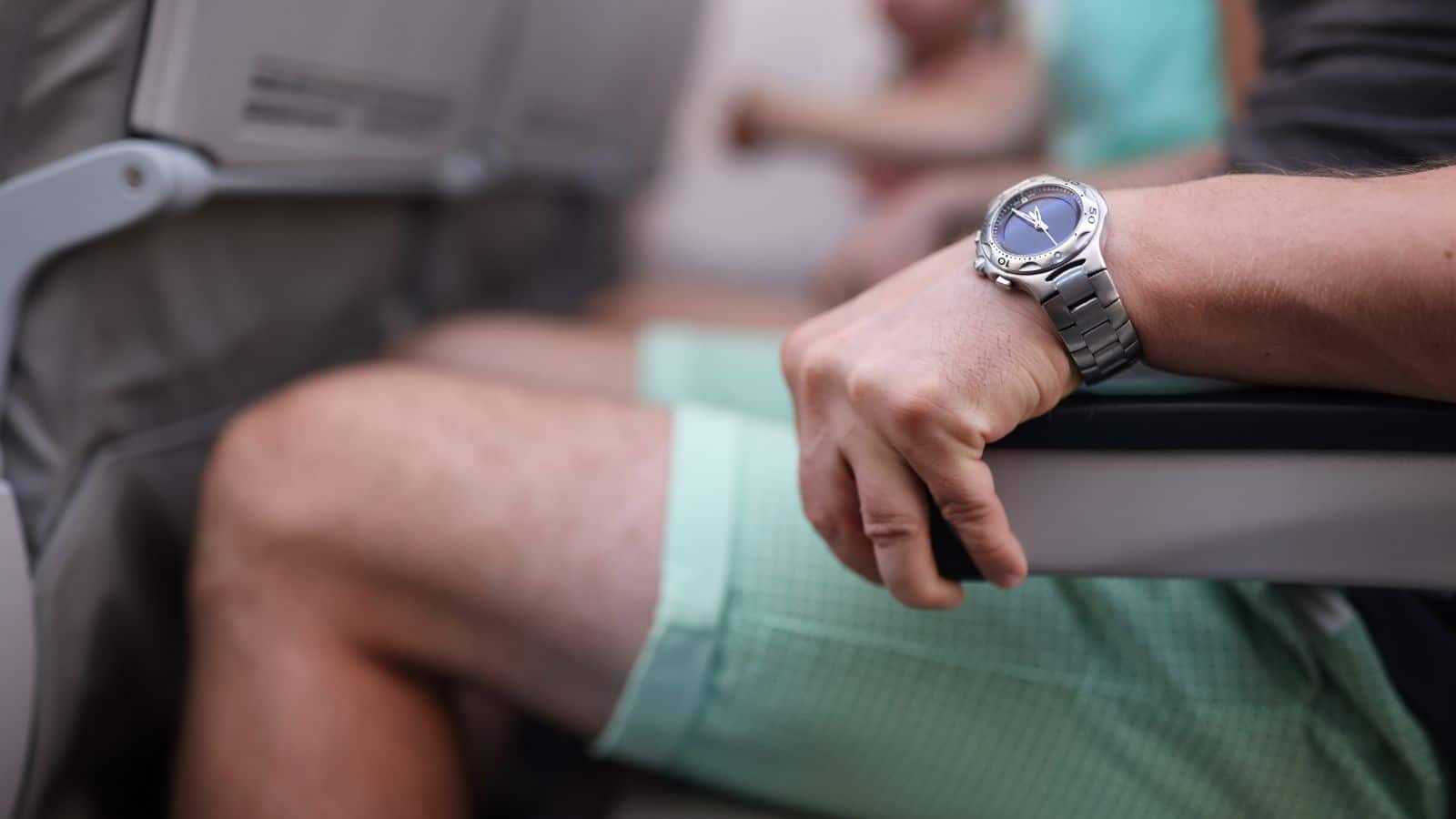 Scared man strongly grab armrest in plane