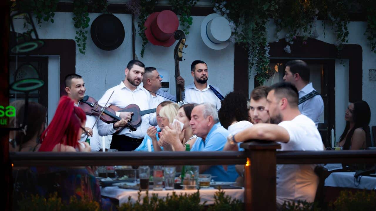 Selective blur on tamburasi, a traditional serbian folk band of tambura, playing in a restaurant in front of guests in Skadarlija street.