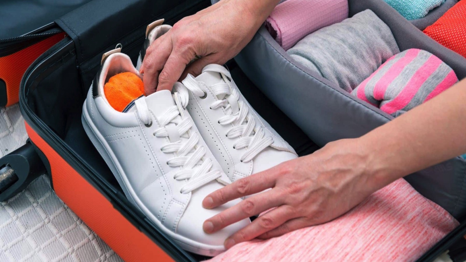 Woman-hands-putting-clothes-to-suitcase-bag-organizer