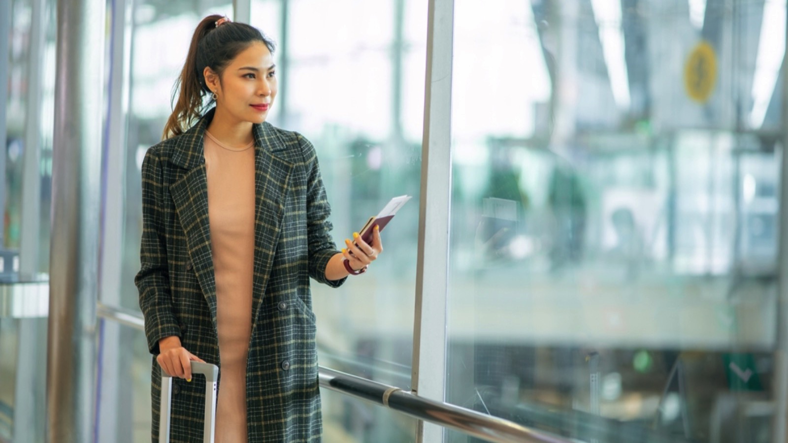 Woman wearing long coat in airport