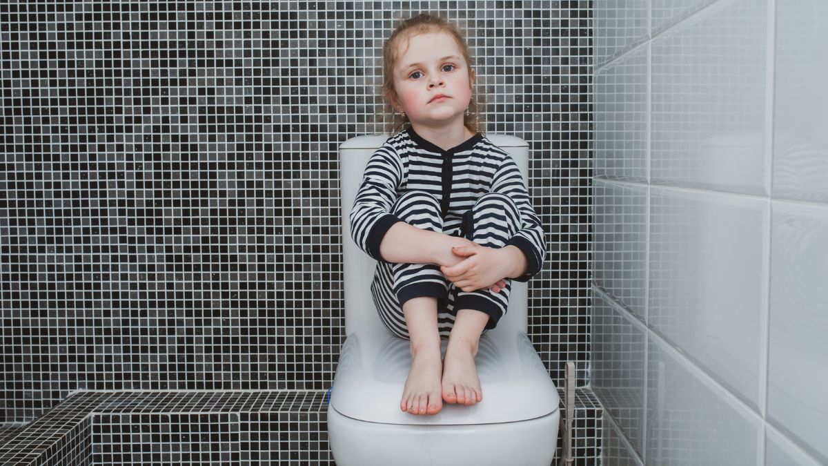 girl-sitting-on-toilet-in-bathroom