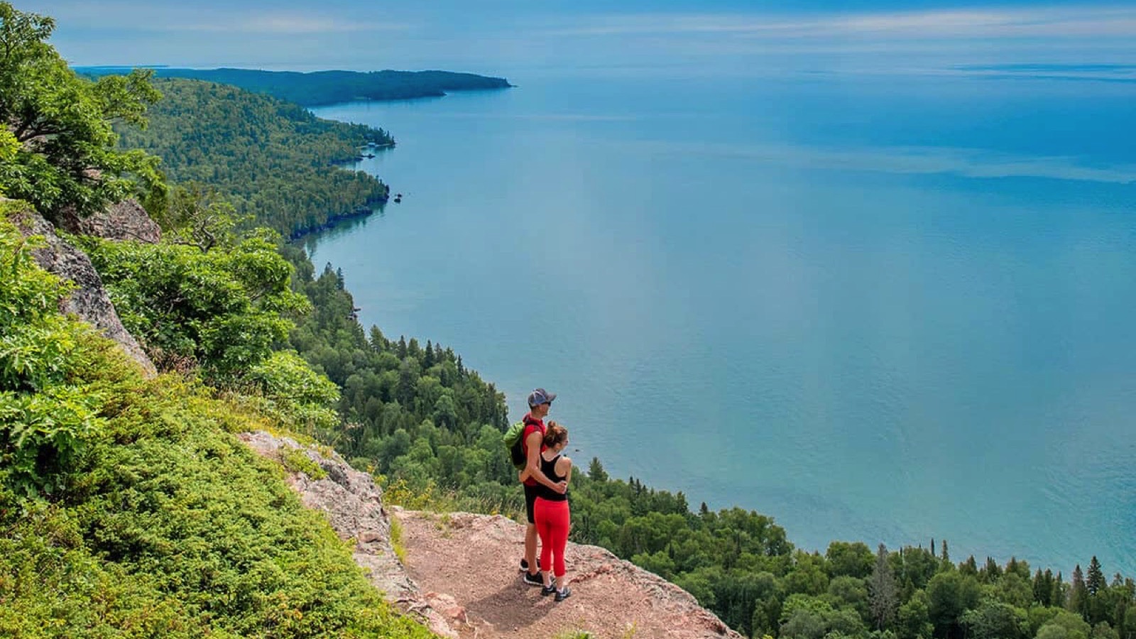 people on hiking trail overlooking water