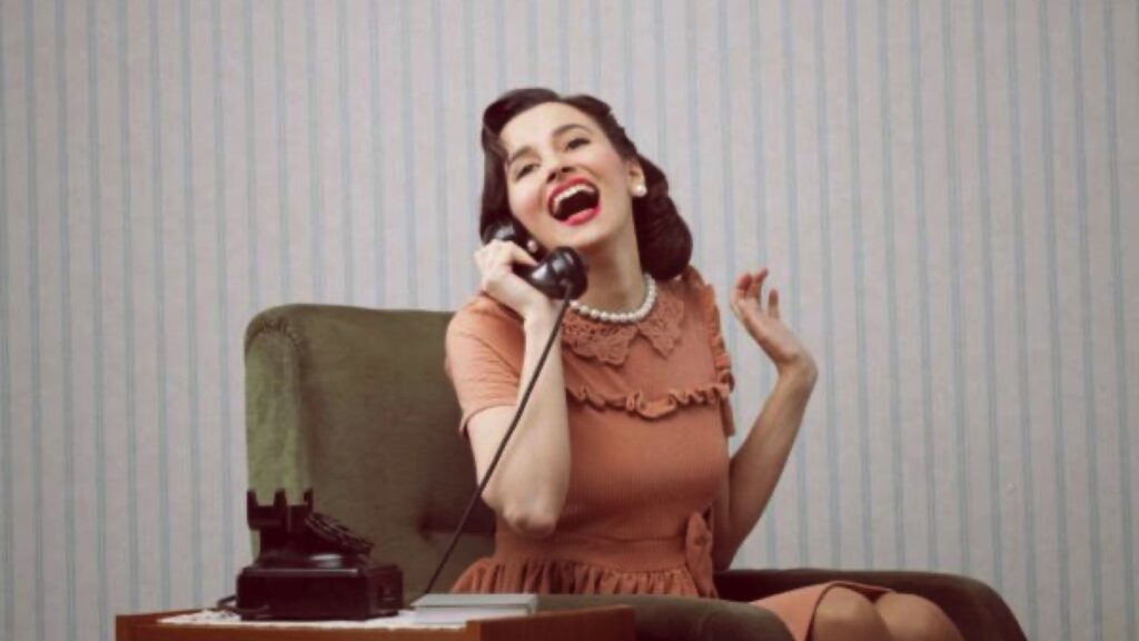 Cheerful woman talking on landline phone