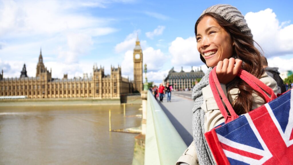 London woman holding shopping bag near Big Ben