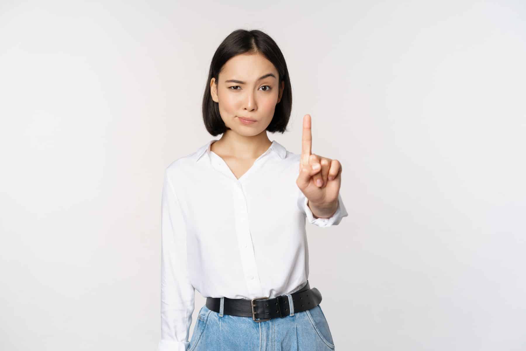 No.Young serious and confident asian woman showing stop