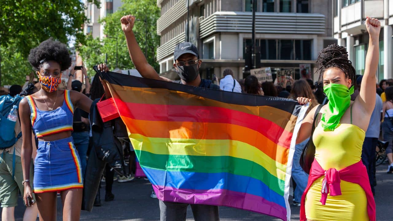 People holding LGBTQ flag