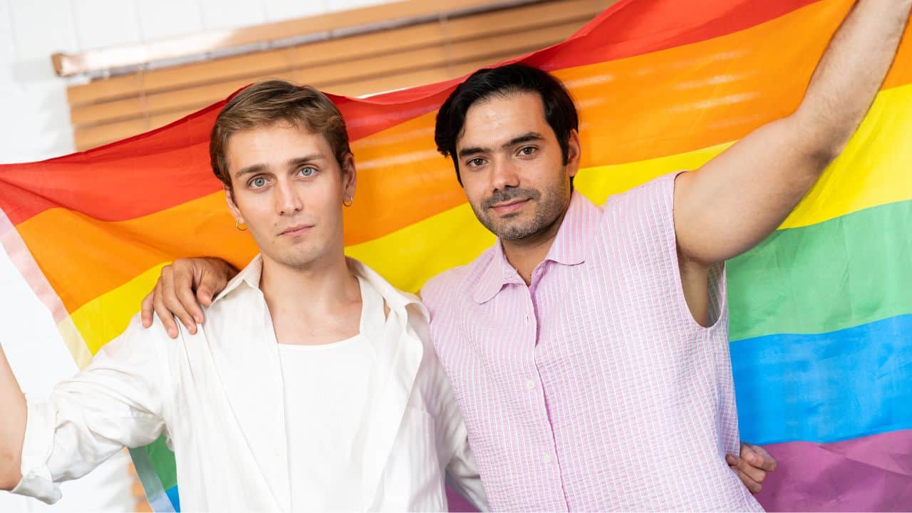 Two men holding LGBTQ flag