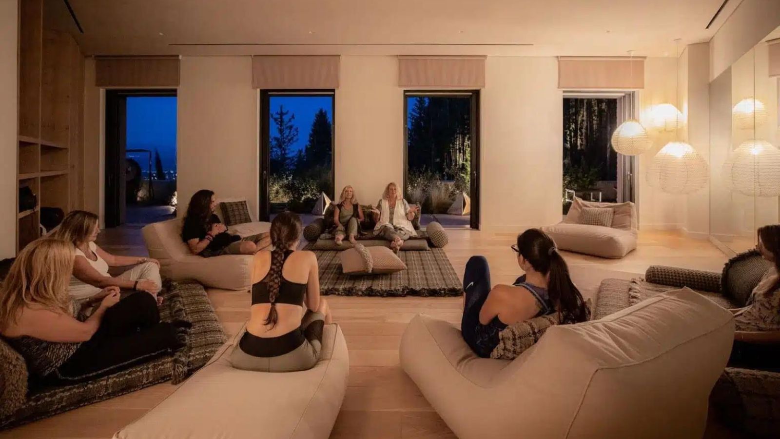 woman in yoga room sitting in a circle on cushions