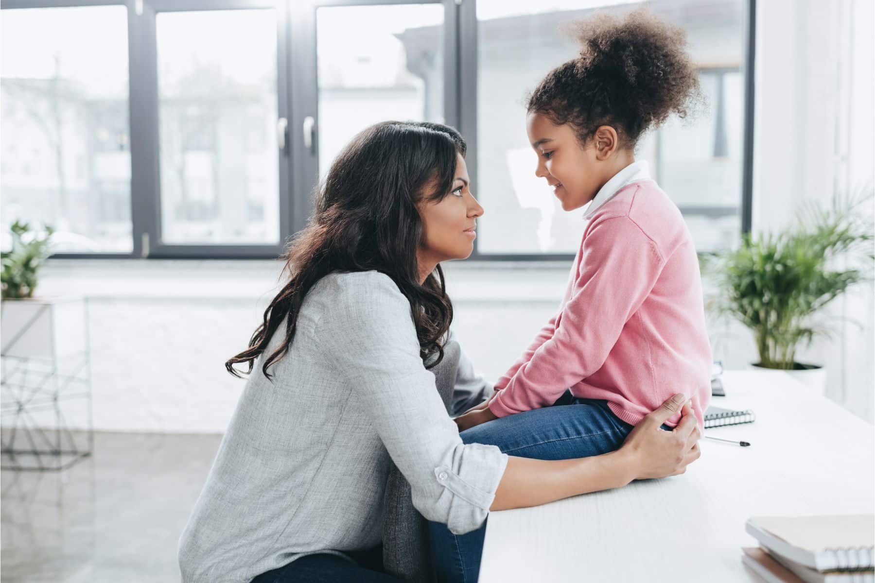 side-view-of-african-american-mother-talking-with-her-daughter-indoors