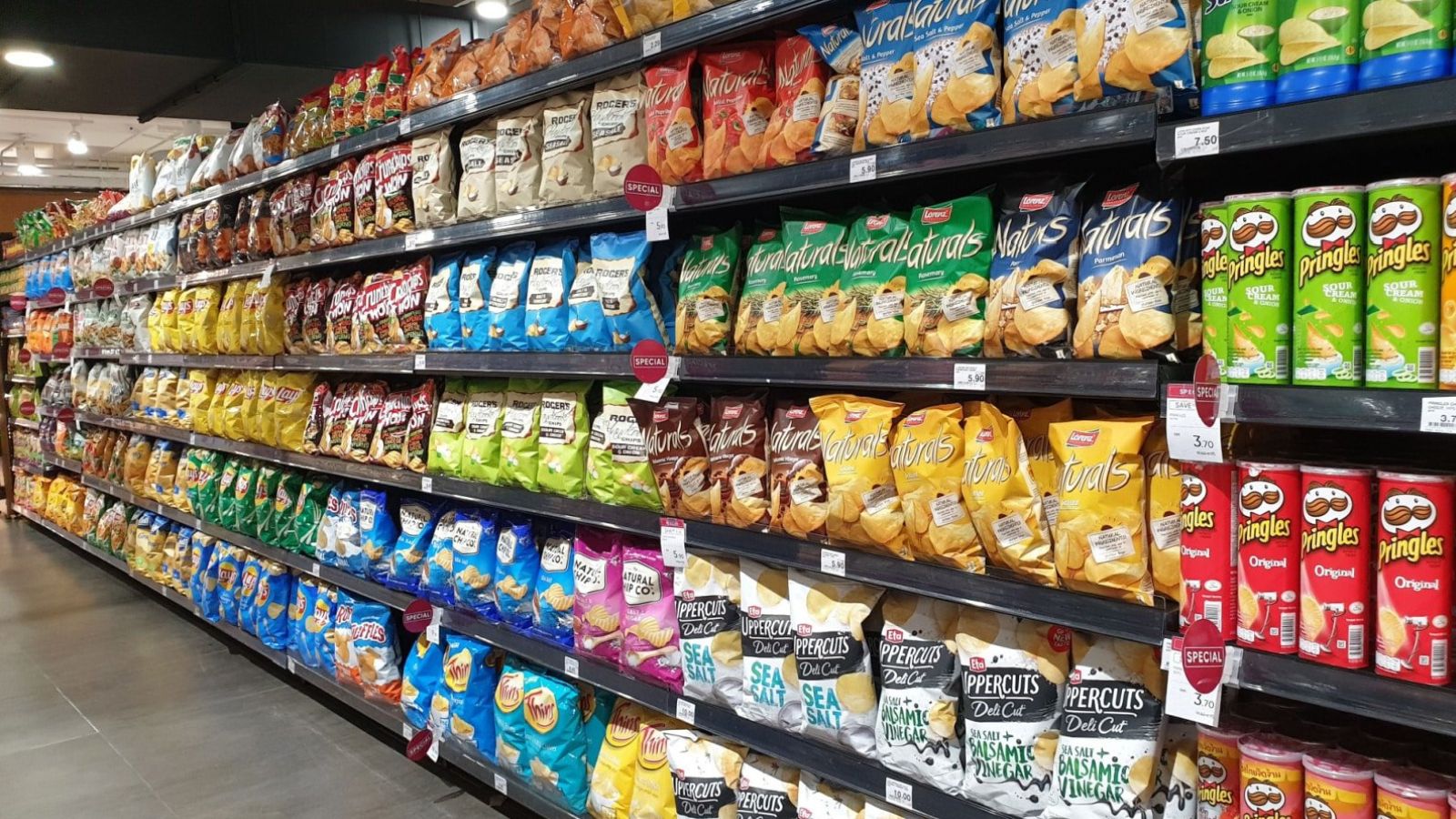 Various local and imported brands of flavoured chips and snacks on store shelf in Mercato grocery store. Mercato is the coolest fresh premium supermarket in Malaysia.