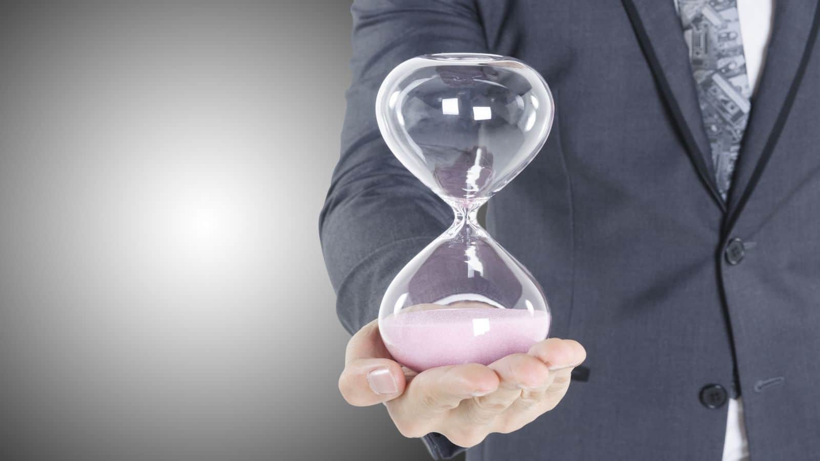 Asian-business-man-wear-grey-suit-holding-sandglass-on-hand