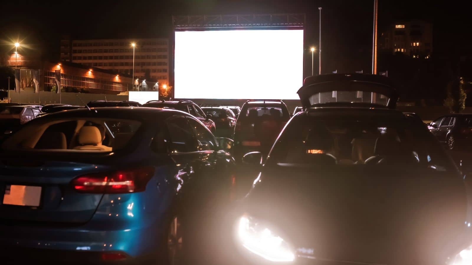 Many-cars-parked-in-front-of-a-big-white-screen