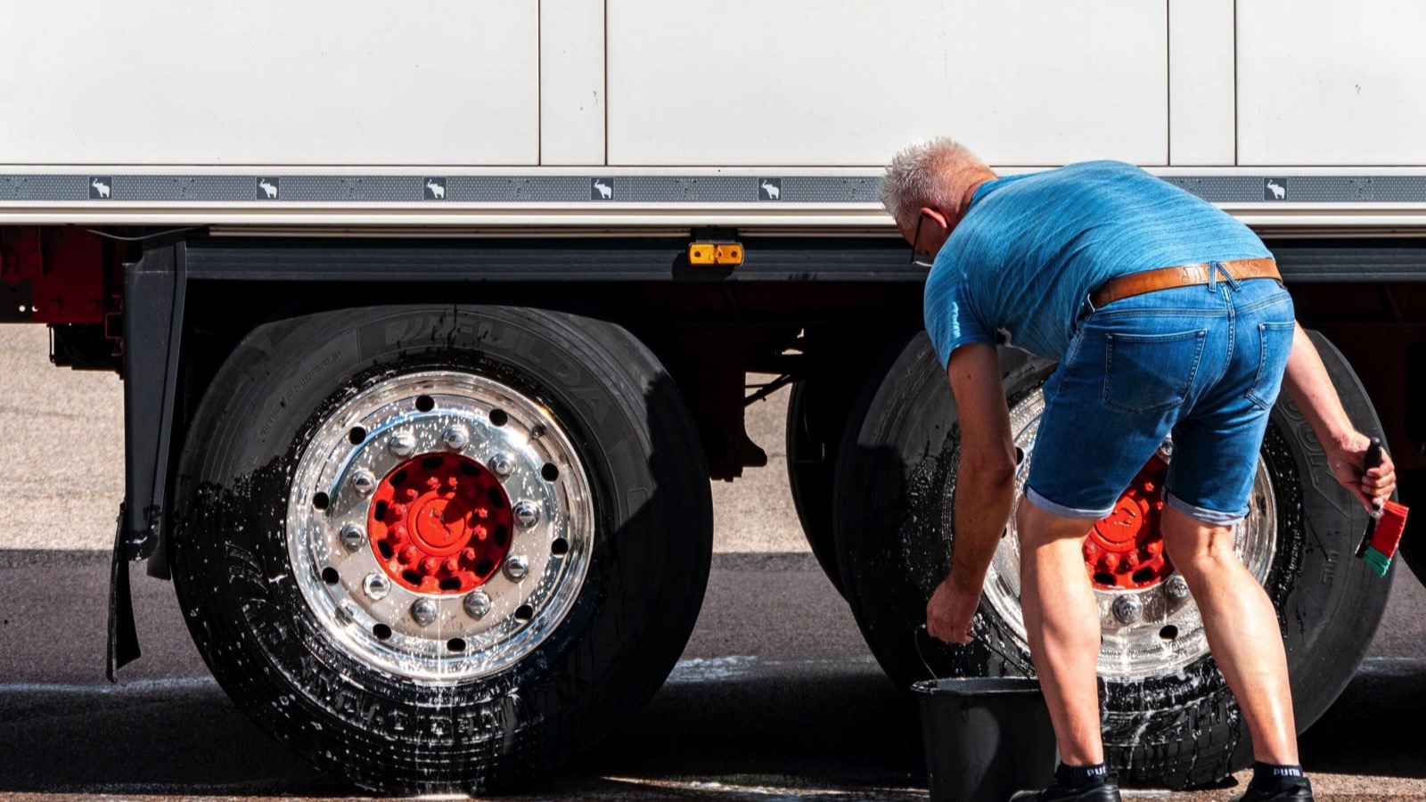 Truck driver washes wheel